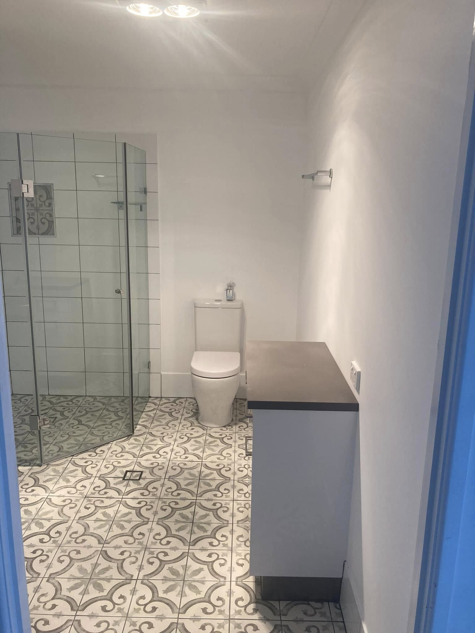 Completed bathroom renovation with patterned floor tiles